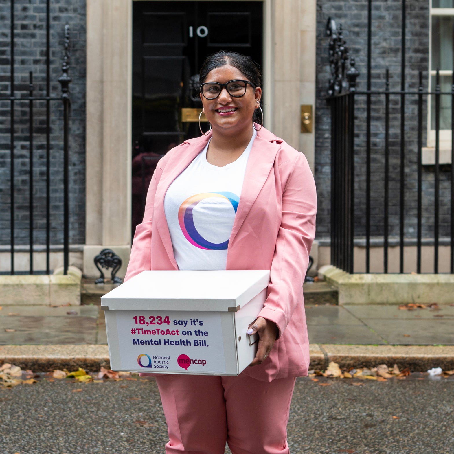 Woman standing outside 10 Downing Street with a petition box